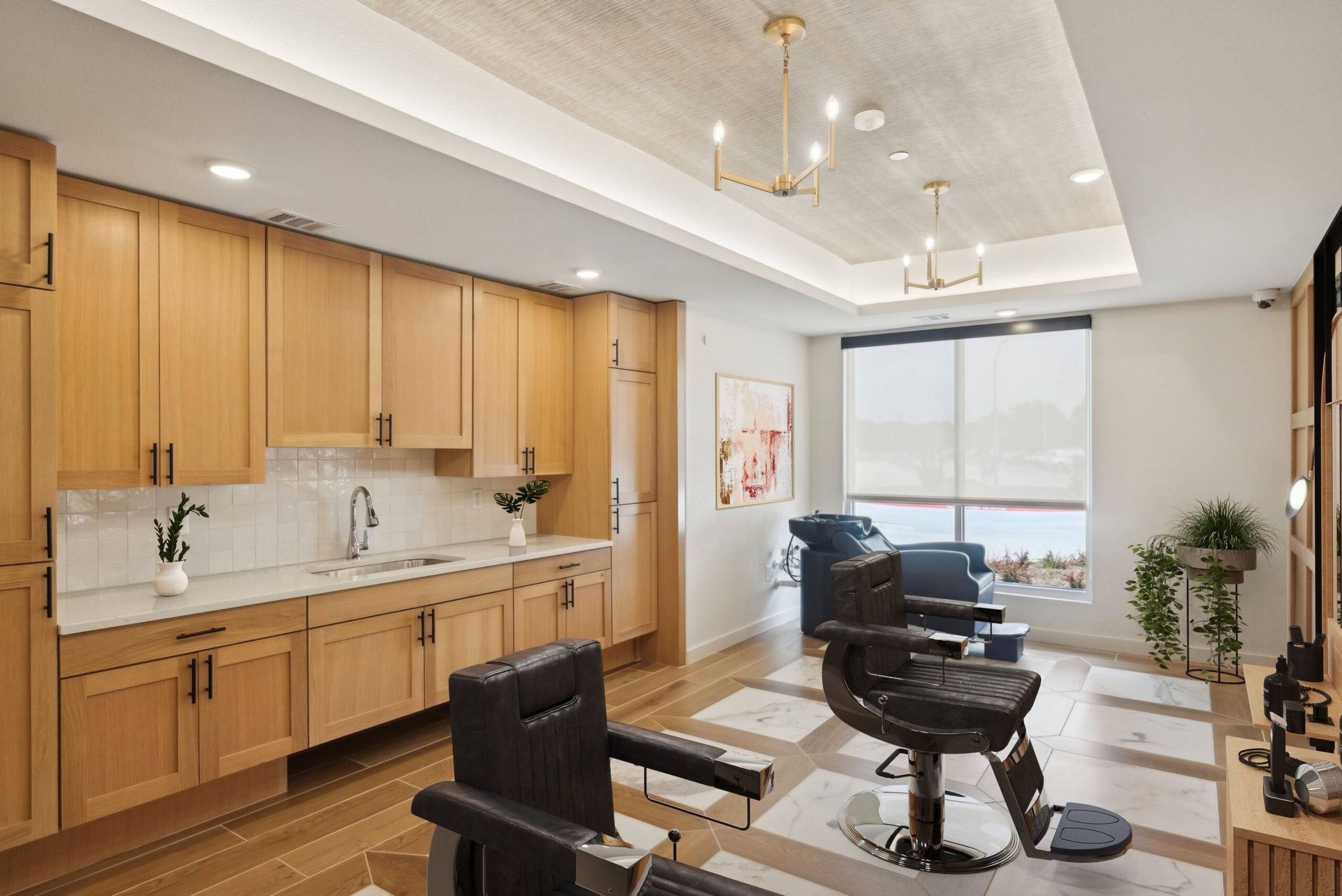 Meridian at Wylie Modern barbershop with wood cabinets, black chairs, large window, and elegant lighting fixtures.